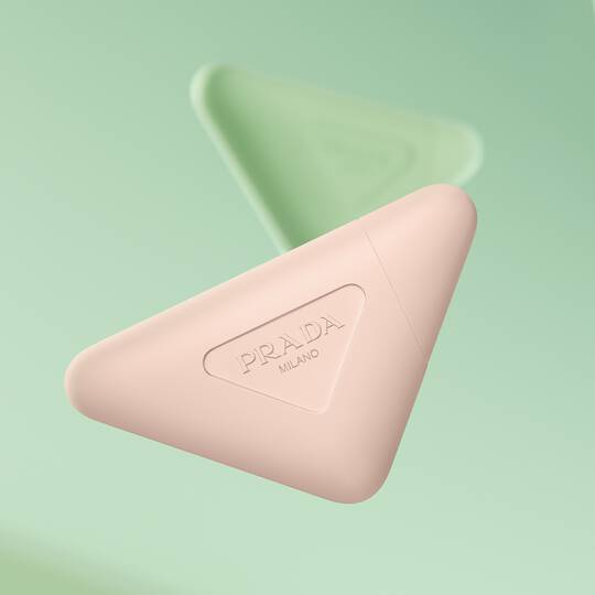 Prada Paradoxe Hand Cream and Prada Hand Cream floating on a green background