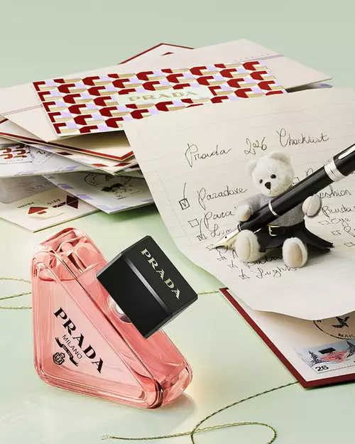 Prada Paradoxe Eau de Parfum in a holiday environment with letters, teddy bear and light green background