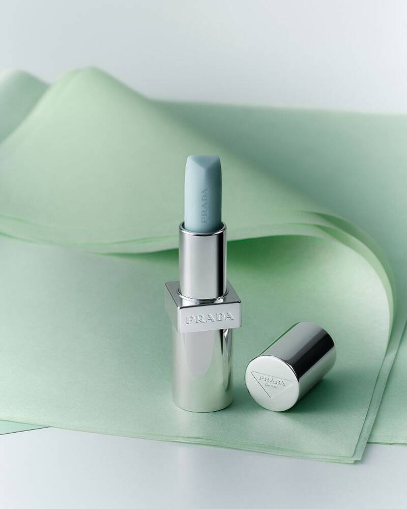 Prada Balm in shade Astral Pink on a textured green background