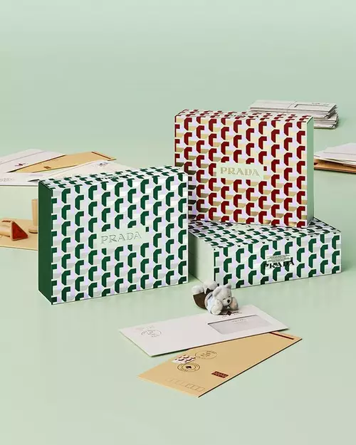 Prada Beauty Digital Services Shipping - Three Holiday Gift Boxes with letters and teddy bear on a light green background