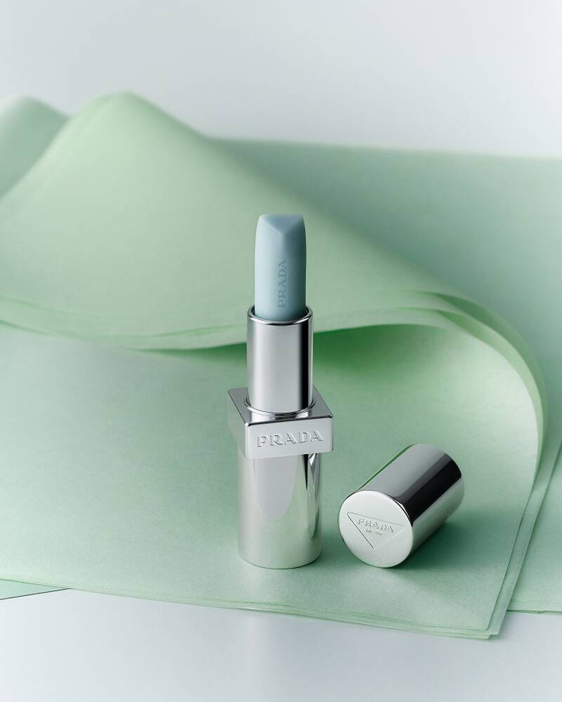Prada Balm in shade Astral Pink on a textured green background