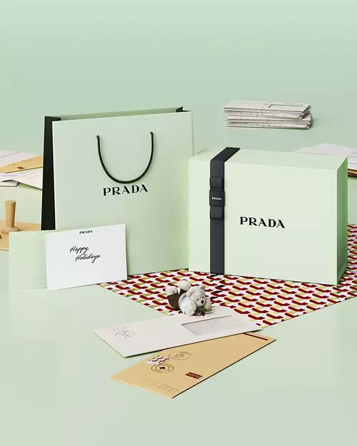 Prada Beauty Digital Services Art of Gifting - Holiday Green Gift Box, bag, card, teddy bears and letters on a light green background