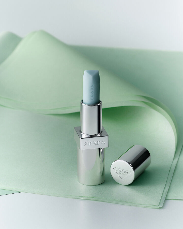 Prada Balm in shade Astral Pink on a textured green background