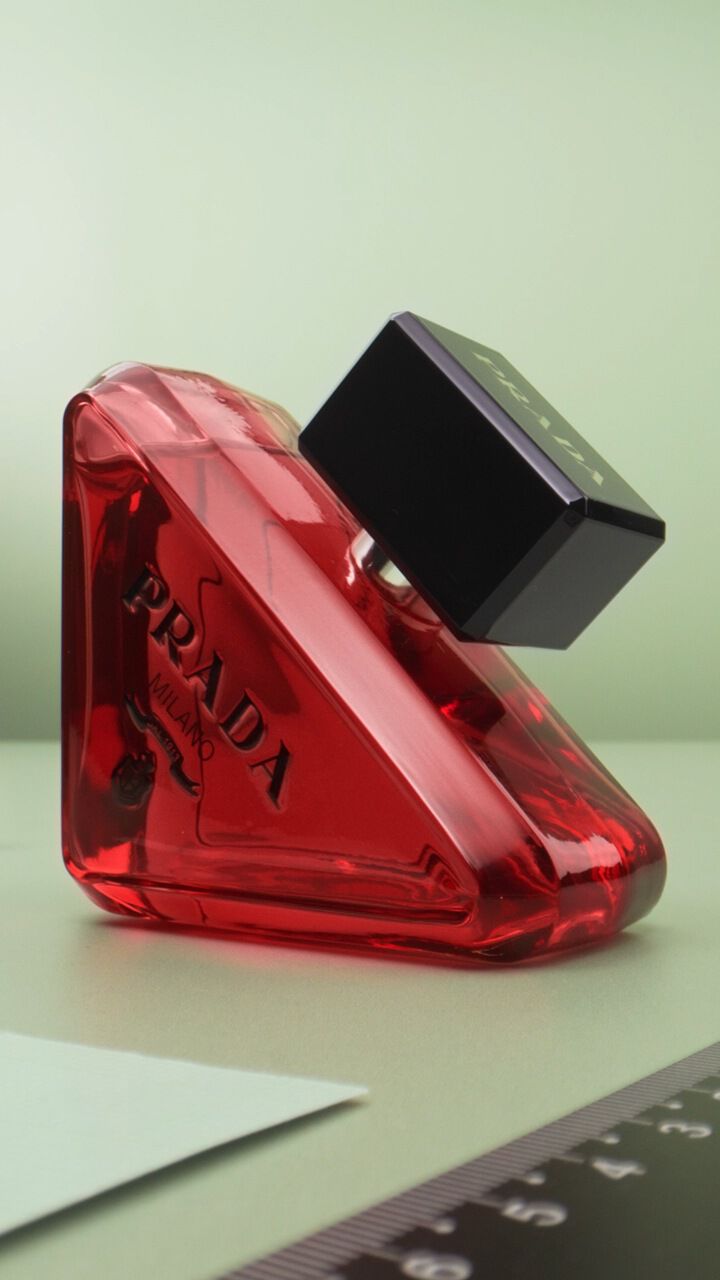Prada Paradoxe Hand Cream Key Visual with Light and Dark skinned hands on a green background