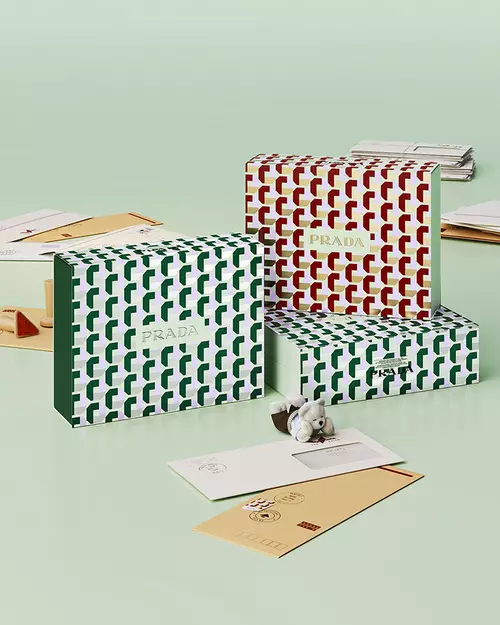 Prada Beauty Digital Services Shipping - Three Holiday Gift Boxes with letters and teddy bear on a light green background