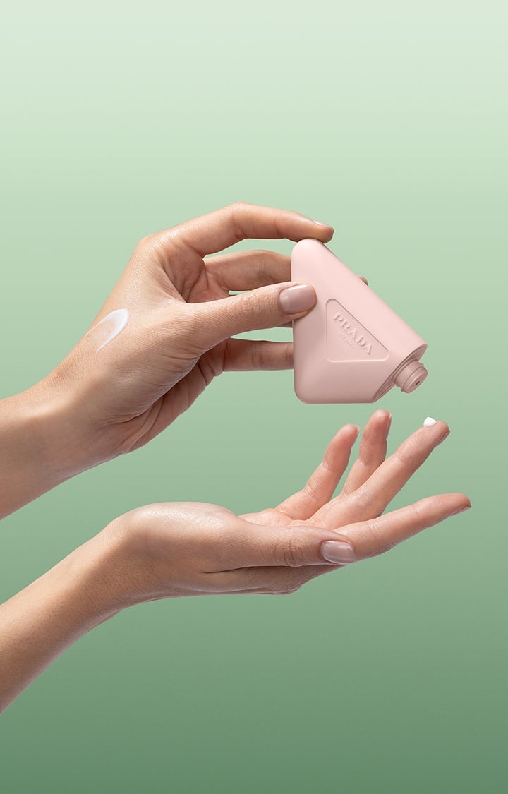 Prada Paradoxe Hand Cream in-hand usage on a Green Background