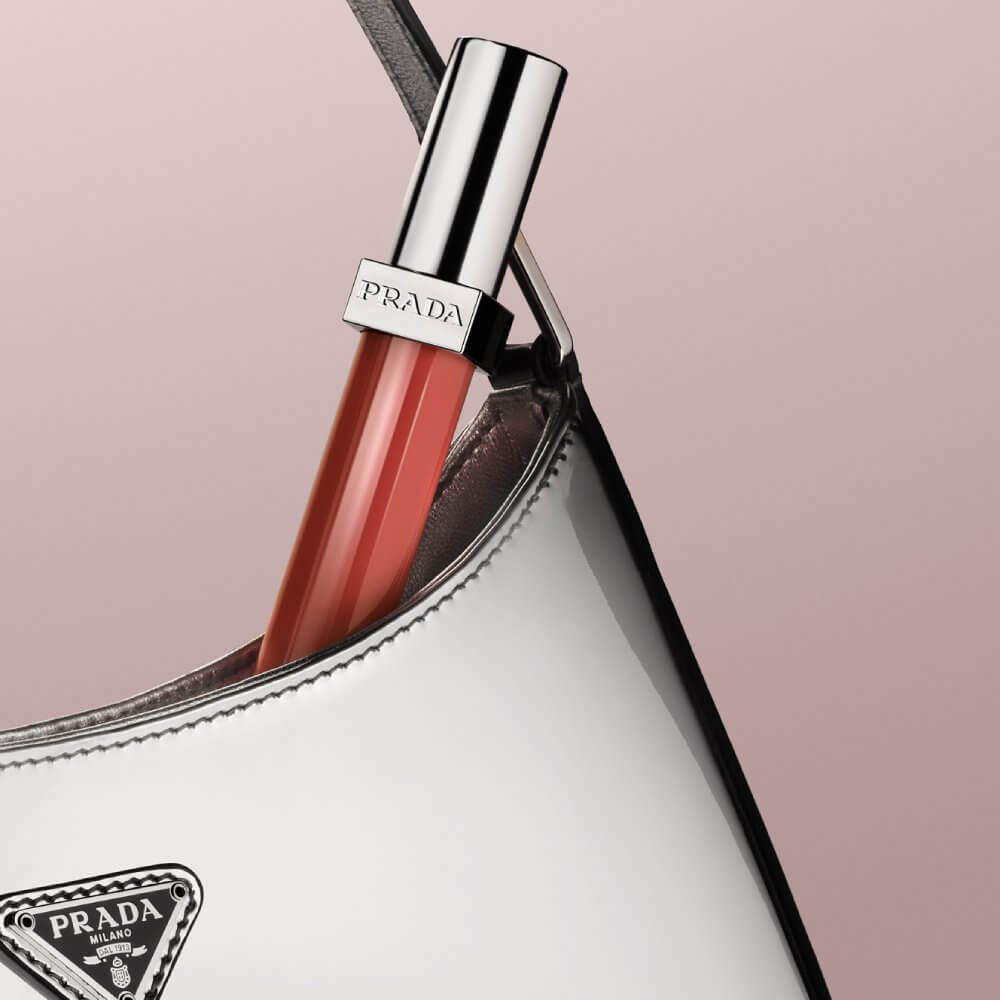 Prada Reflection Glossy Liquid Balm in shade Firemotion in a chrome Prada Cleo bag.
