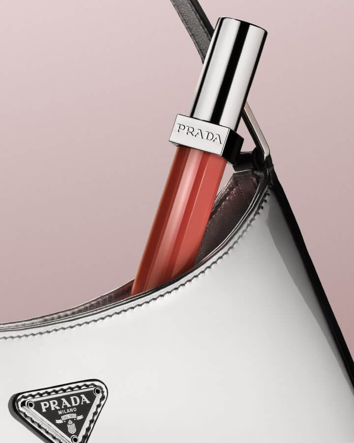 Prada Reflection Glossy Liquid Balm in shade Firemotion in a chrome Prada Cleo bag.